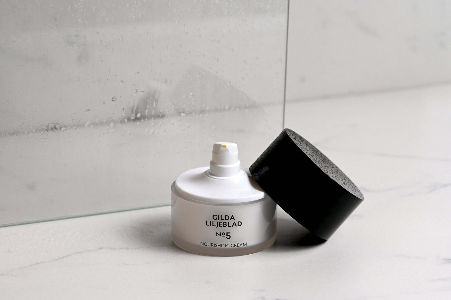 Gilda Liljeblad N5 no-wrinkle cream on a marble surface with a glass backdrop, ideal for dry, flaky skin.